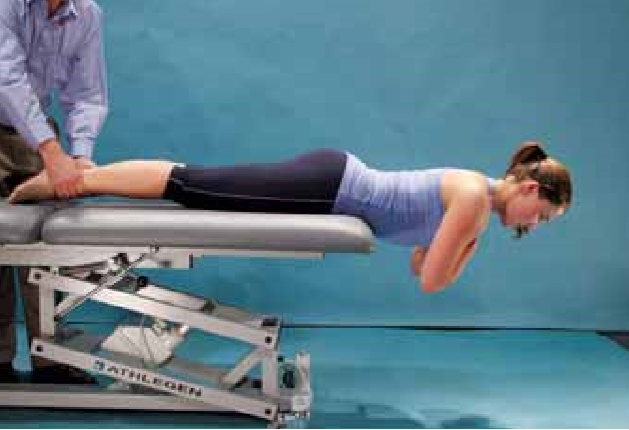 prova di resistenza estensore. L'atleta è incline oltre il bordo del divano con il bacino, fianchi e ginocchia protetti. Gli arti superiori sono tenute in tutto il petto con le mani appoggiate sulle spalle opposte